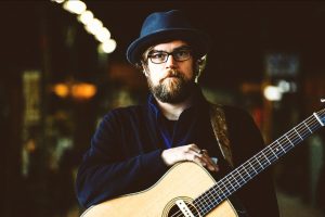 Aaron Burdett with acoustic guitar